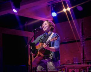 Nika @probablyacoustic at Revelry Nika @probablyacoustic stands on a large lit up stage and is smiling at Revelry Kelowna
Full Circle Photography